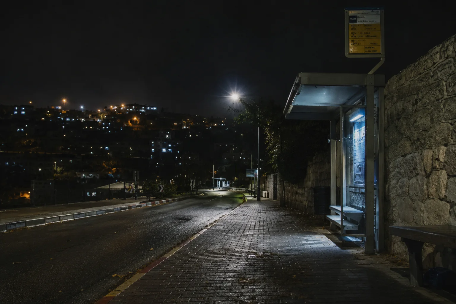 תחנת אוטובוס ריקה בשעת לילה במזרח ירושלים